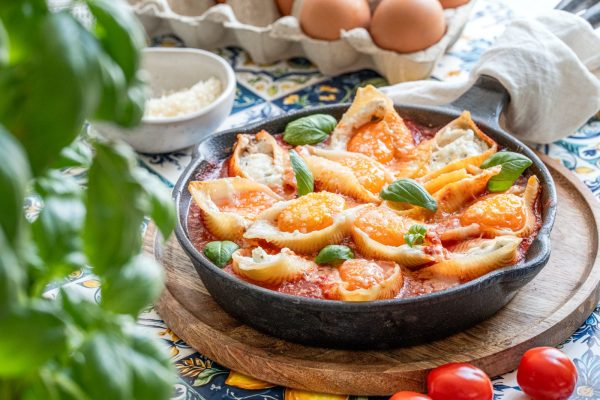 Töltött óriás kagylótészta serpenyőben paradicsomágyon